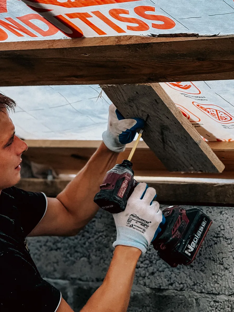Installer fastening insulation with a drill